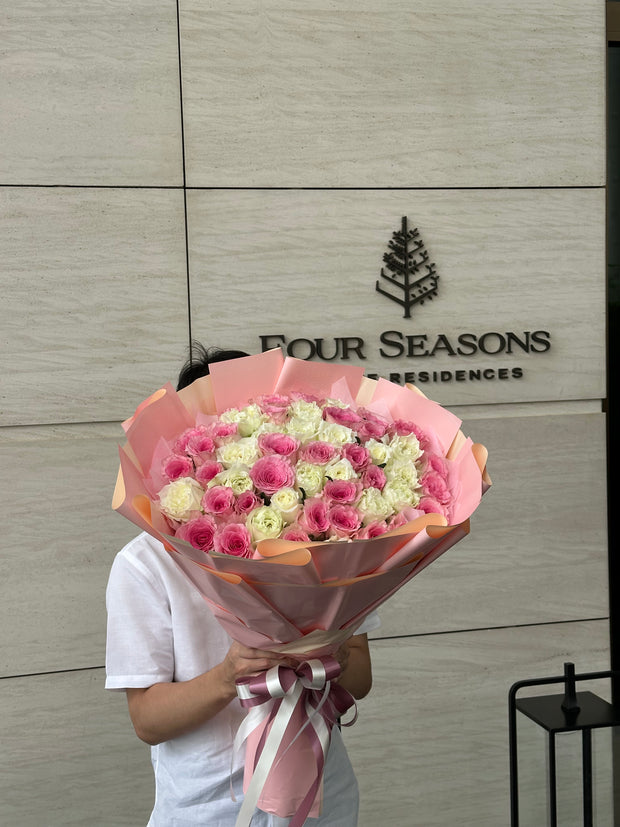 Man holding a luxurious 100 mixed white and pink roses bouquet – DP FLOWERS BANGKOK hotel flower delivery for VIP and special occasions