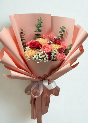 Vibrant coral pink roses and golden yellow carnations bouquet with burgundy carnations wrapped in dusty rose paper - colorful flower delivery Bangkok | DP FLOWERS BANGKOK