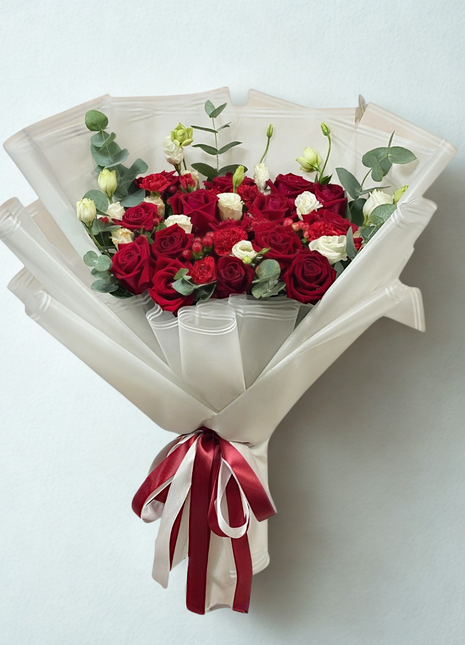 A classic, passionate bouquet of deep red and white roses with white lisianthus, wrapped in pure white paper with a red and white ribbon - Valentine's/Anniversary flower delivery Bangkok | DP FLOWERS BANGKOK