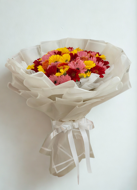 Vibrant mixed gerbera daisy bouquet with yellow, pink, red and orange flowers wrapped in white paper - cheerful delivery Bangkok | DP FLOWERS BANGKOK
