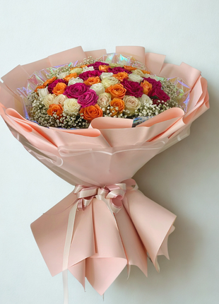 Vibrant mixed rose bouquet with fuchsia, orange and cream roses wrapped in pink paper with iridescent accents - celebration delivery Bangkok | DP FLOWERS BANGKOK