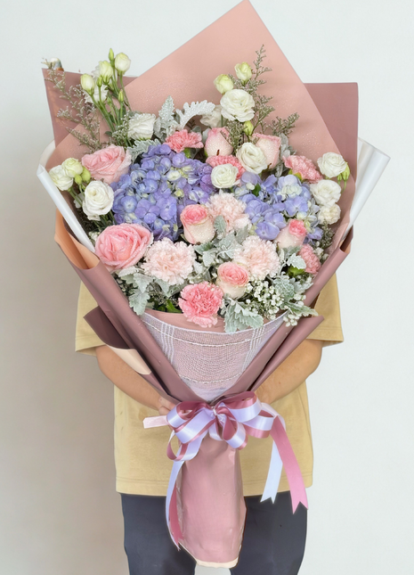 Elegant pastel bouquet with purple hydrangeas, pink carnations, white roses and dusty miller in pink burlap wrapping - premium flower delivery Bangkok | DP FLOWERS BANGKOK