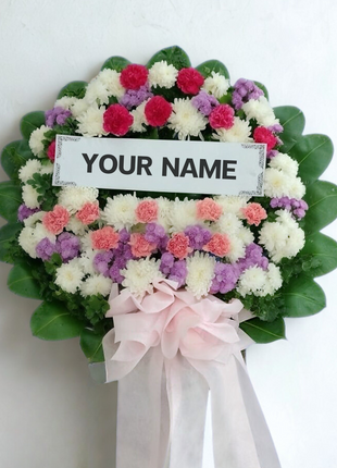 Colorful funeral wreath with pink carnations, purple statice, white chrysanthemums and personalized nameplate - vibrant memorial delivery Bangkok | DP FLOWERS BANGKOK