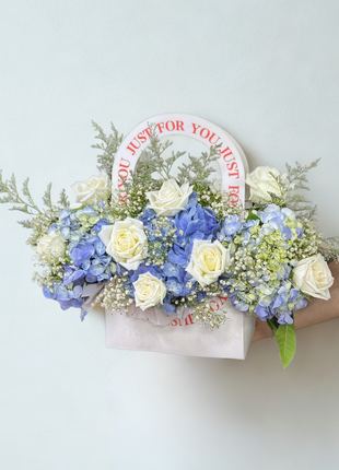 White roses and blue hydrangeas arrangement in wooden basket with "Just For You" message - fresh flower delivery Bangkok | DP FLOWERS BANGKOK