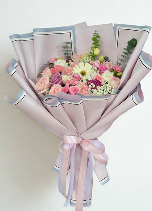 Elegant mixed garden bouquet with pink roses, purple lisianthus, carnations and cream gerberas wrapped in modern pink and blue bordered paper - fresh flower delivery Bangkok | DP FLOWERS BANGKOK