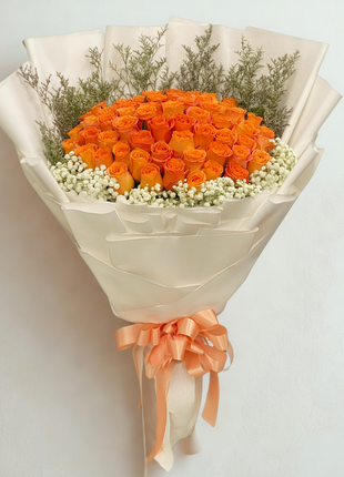 Large vibrant orange roses bouquet with baby's breath and caspia wrapped in ivory paper with orange ribbon - fresh flower delivery Bangkok | DP FLOWERS BANGKOK