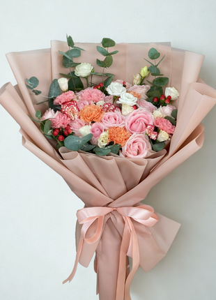 A soft, monochromatic bouquet of pink roses and coral/pink carnations with eucalyptus, wrapped in matching blush pink paper and ribbon - Romantic/Anniversary flower delivery Bangkok | DP FLOWERS BANGKOK