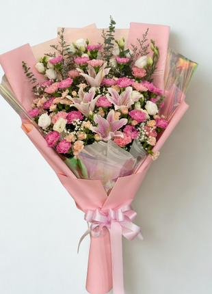 Elegant pink lily and carnation bouquet with peach roses and white eustoma wrapped in pink paper - fresh flower delivery Bangkok | DP FLOWERS BANGKOK