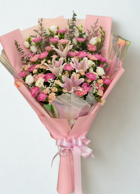 Elegant pink lily and carnation bouquet with peach roses and white eustoma wrapped in pink paper - fresh flower delivery Bangkok | DP FLOWERS BANGKOK