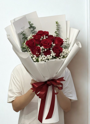 Nine premium red roses bouquet with baby's breath and eucalyptus in white wrapping held by person - eternal love Valentine's Day delivery Bangkok | DP FLOWERS BANGKOK