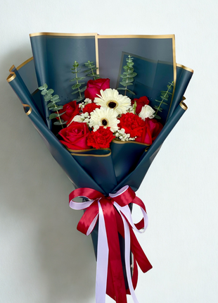 Luxurious deep red roses and white gerbera daisies bouquet wrapped in navy blue paper with gold trim and burgundy ribbons - premium flower delivery Bangkok | DP FLOWERS BANGKOK