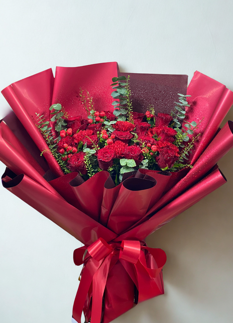Dramatic deep red roses and carnations bouquet with berries wrapped in crimson paper - passionate flower delivery Bangkok | DP FLOWERS BANGKOK