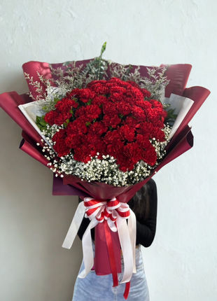 Spectacular red carnations bouquet with baby's breath wrapped in burgundy paper with red ribbon - premium flower delivery Bangkok | DP FLOWERS BANGKOK