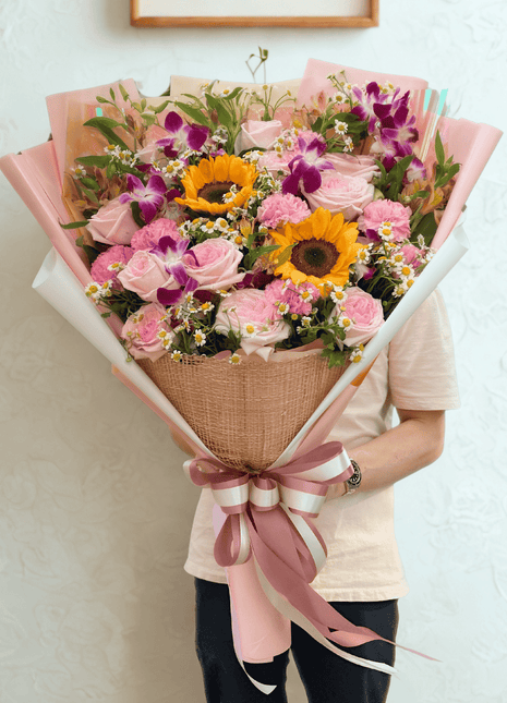 Colorful garden festival bouquet with sunflowers, purple orchids, pink roses and daisies in burlap wrap - fresh flower delivery Bangkok | DP FLOWERS BANGKOK