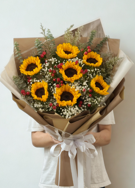 A large bouquet of 6 vibrant sunflowers with Baby's Breath and eucalyptus, wrapped in craft brown paper and white ribbon - Graduation/Success flower delivery Bangkok | DP FLOWERS BANGKOK