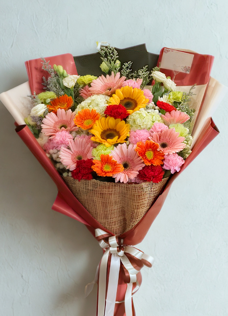 Colorful bouquet with yellow gerbera daisies, orange roses, and pink carnations – DP FLOWERS BANGKOK