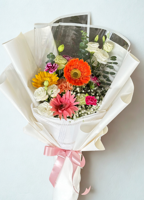 Vibrant mixed bouquet with orange, pink and yellow gerbera daisies and white roses in white wrapping - cheerful flower delivery Bangkok | DP FLOWERS BANGKOK