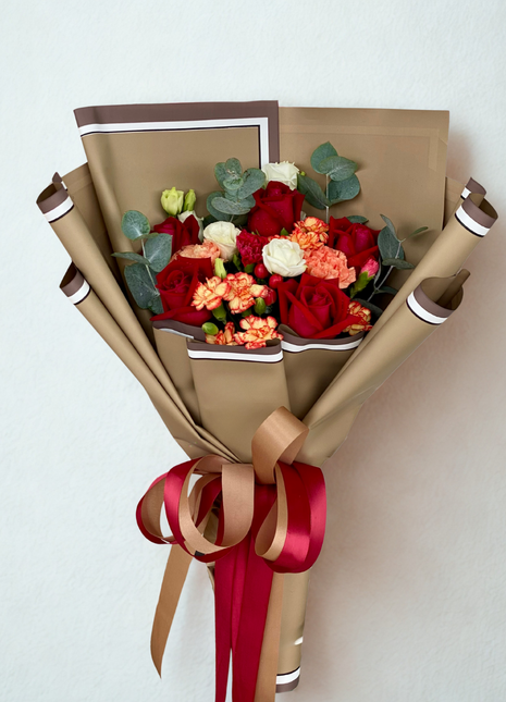 A passionate bouquet of red and white roses with coral carnations and eucalyptus, wrapped in layered brown/kraft paper with red and gold ribbon - Rustic/Anniversary flower delivery Bangkok | DP FLOWERS BANGKOK