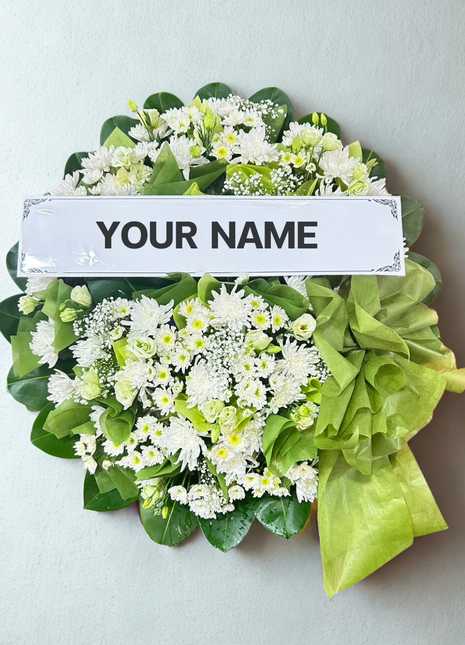 Elegant white chrysanthemum funeral wreath with green foliage and lime ribbon - memorial flower delivery Bangkok | DP FLOWERS BANGKOK