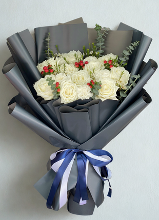 Sophisticated white rose and carnation bouquet with red hypericum berries in navy wrapping with navy ribbon - luxury corporate delivery Bangkok | DP FLOWERS BANGKOK