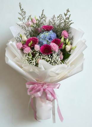Charming mixed bouquet with fuchsia gerberas, blue hydrangeas, pink lisianthus and wild foliage in white wrapping - garden flower delivery Bangkok | DP FLOWERS BANGKOK