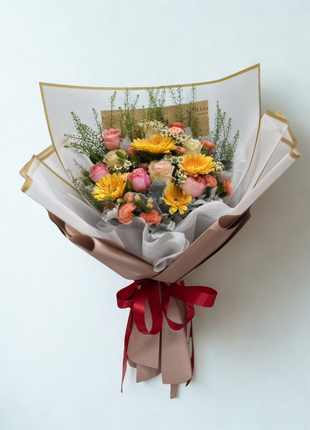 Premium yellow Gerberas and pink roses mixed bouquet with gold trim wrapping and burgundy ribbon - elegant flower delivery Bangkok | DP FLOWERS BANGKOK