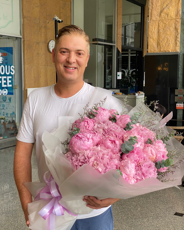 Happy man holding a beautiful bouquet from DP FLOWERS BANGKOK – real customer review, surprised with flower delivery