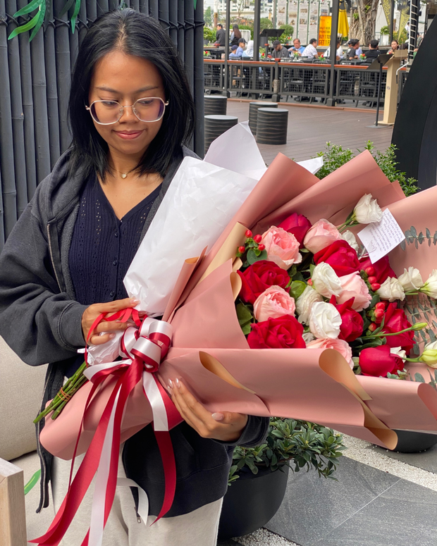 Happy woman holding a beautiful bouquet from DP FLOWERS BANGKOK – real customer review, surprised with flower delivery